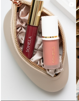 Lipstick and lip gloss inside a cosmetic pouch, representing beauty and self-care products.